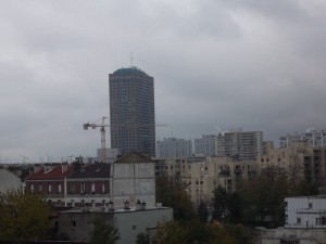 Une tour entourée de grue domine des immeubles sous un ciel gris de novembre